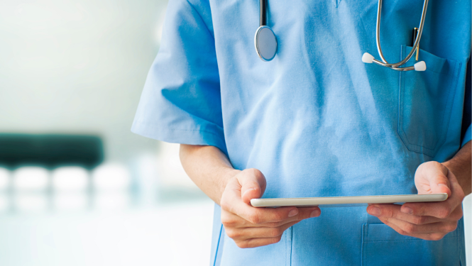 Medicīnas darbinieka rokas, kas tur rokās planšeti