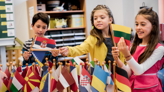 Trīs bērni ar dažādu Eiropas valstu karodziņiem rokās