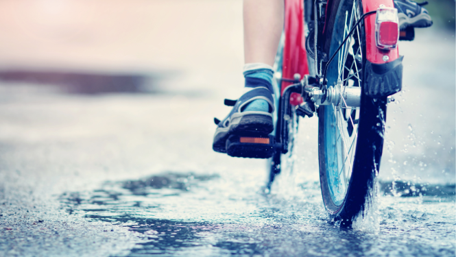 Velosipēds brauc pa peļķi