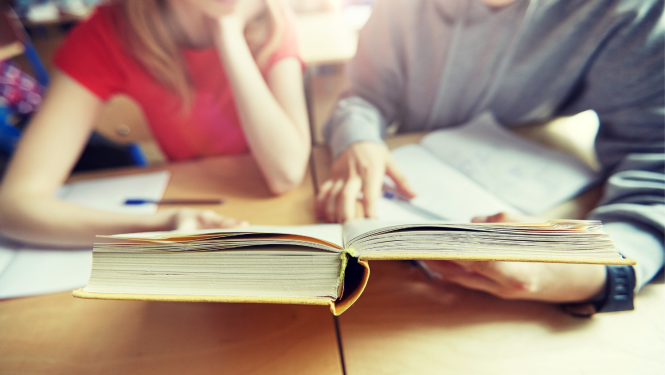 Bērni mācās, priekšplānā atvērta grāmata