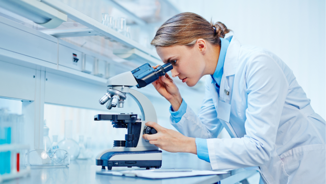 Pētniece skatās mikroskopā 