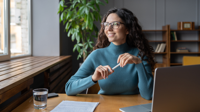 Sieviete sēž pie galda un smaida