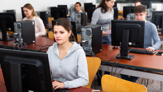 Jaunieši datorklasē pie datoriem