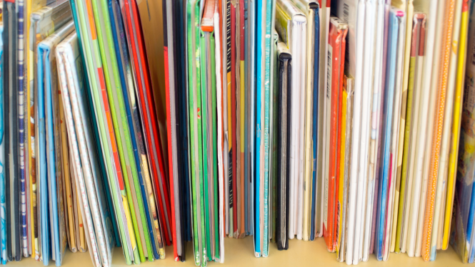 Daudz plānu, krāsainu grāmatu plauktā