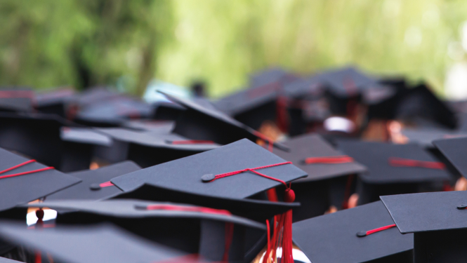 Attēlā redzamas absolventu cepures no augšas 