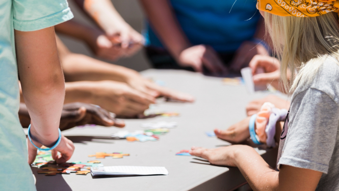 bērni liek puzli pie galda