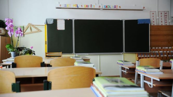 Klase ar skolas soliem, uz sienas redzama tāfele.