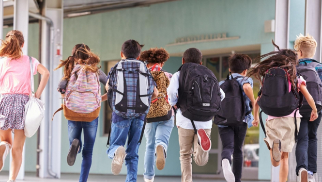 bērni skrien pa skolas gaiteni