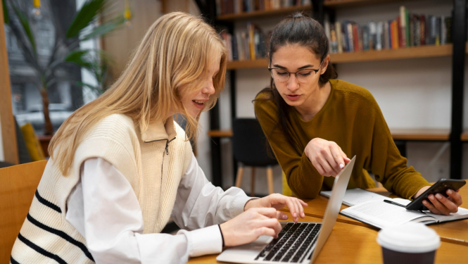 Divas studentes mācās pie datora 