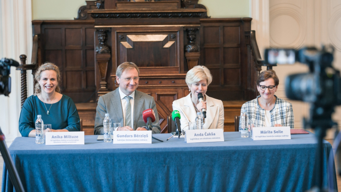 Preses konferencē pie galda ar zilu galdautu sēž izglītības un zinātnes ministre Anda Čakša, LU rektors Gundars Bērziņš, LU Izglītības zinātņu un psiholoģijas fakultātes (IZPF) studiju prodekāne profesore Anika Miltuze un LU Izglītības inovāciju nodaļas vadītāja Mārīte Seile