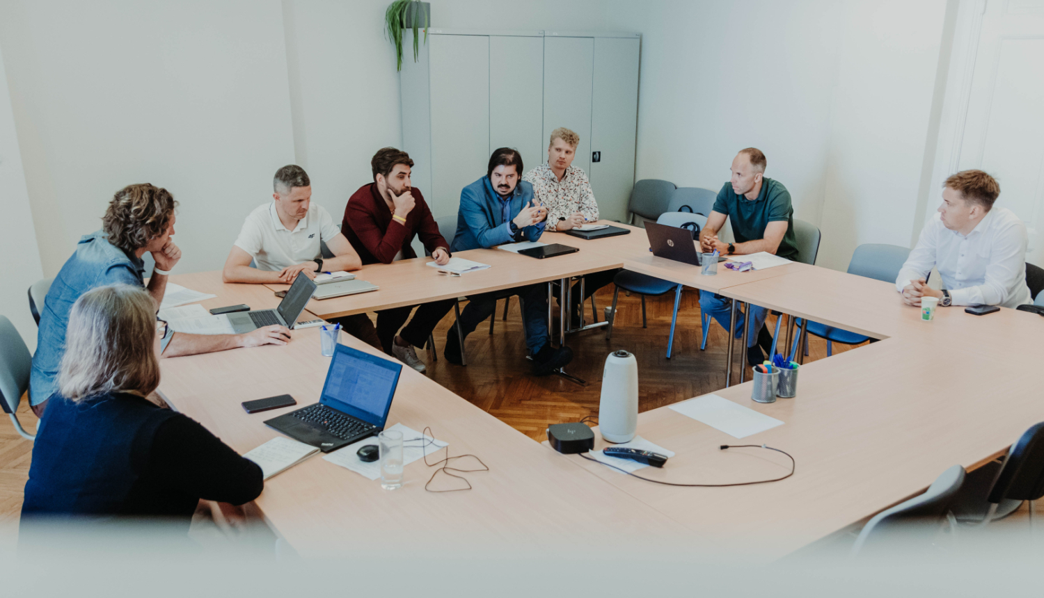 IZM uzsāk darbu pie jaunā sporta finansēšanas modeļa, cilvēki tikšanās sēdē sasēdušies ap galdu. 