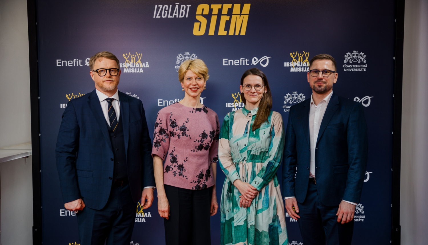 RTU rektors Tālis Juhna, izglītības un zinātnes ministre Anda Čakša, nodibinājuma “Iespējamā misija” valdes priekšsēdētāja Ramona Urtāne un "Enefit" valdes priekšsēdētājs Mārtiņš Vancāns stāv pie fotosienas ar uzrakstu "Izglābt STEM" 