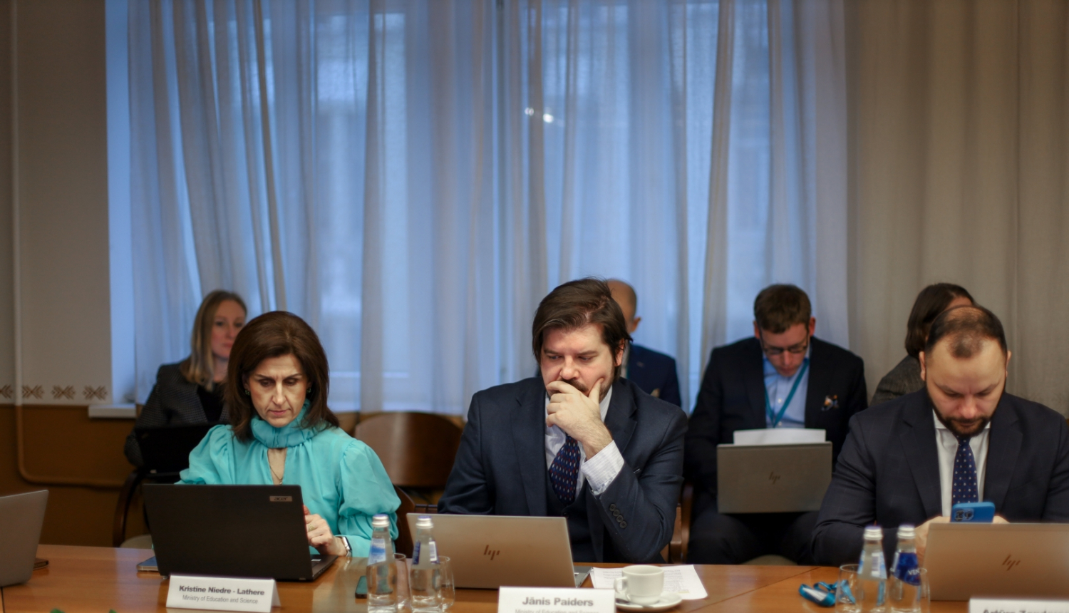 Jānis Paiders un Kristīne Niedre-Lathere sēž pie galda sanāksmē