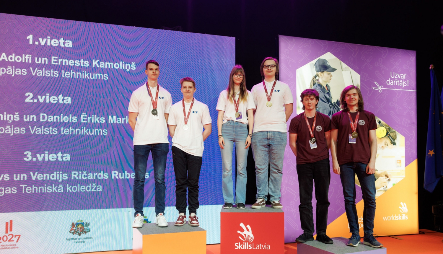 Skills Latvija 2024 konkursa uzvarētāji ar medaļām stāv uz 1.,2. un 3. vietas goda pjedestāla