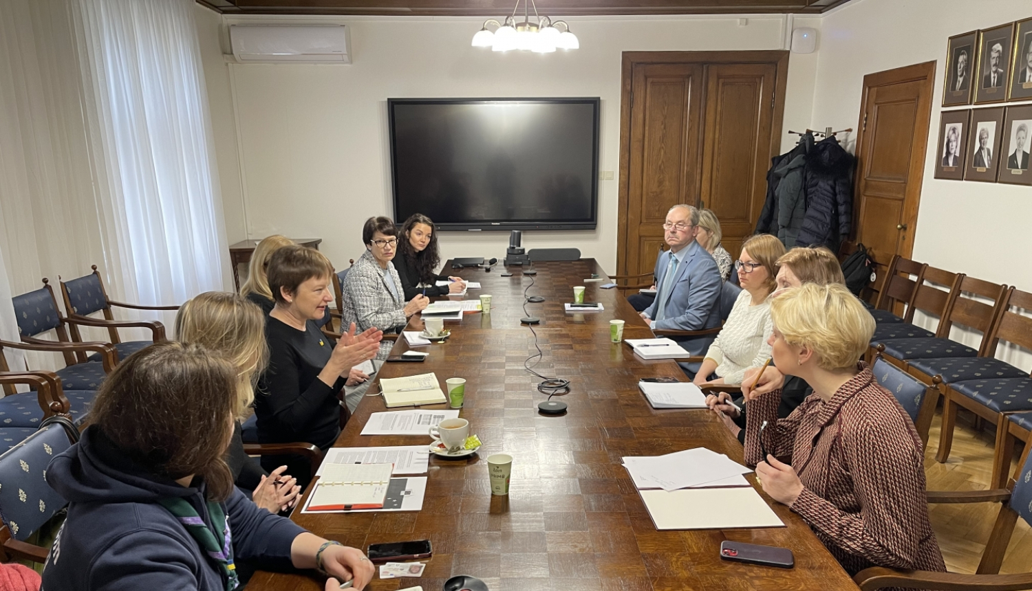 cilvēki sarunājas pie galda