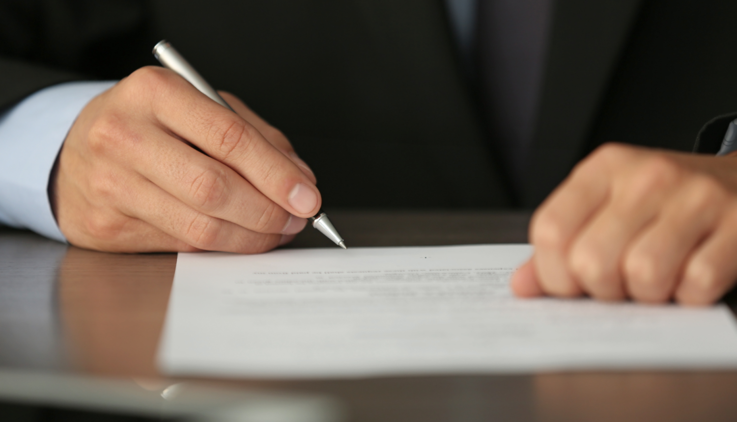 cilvēks paraksta dokumentu