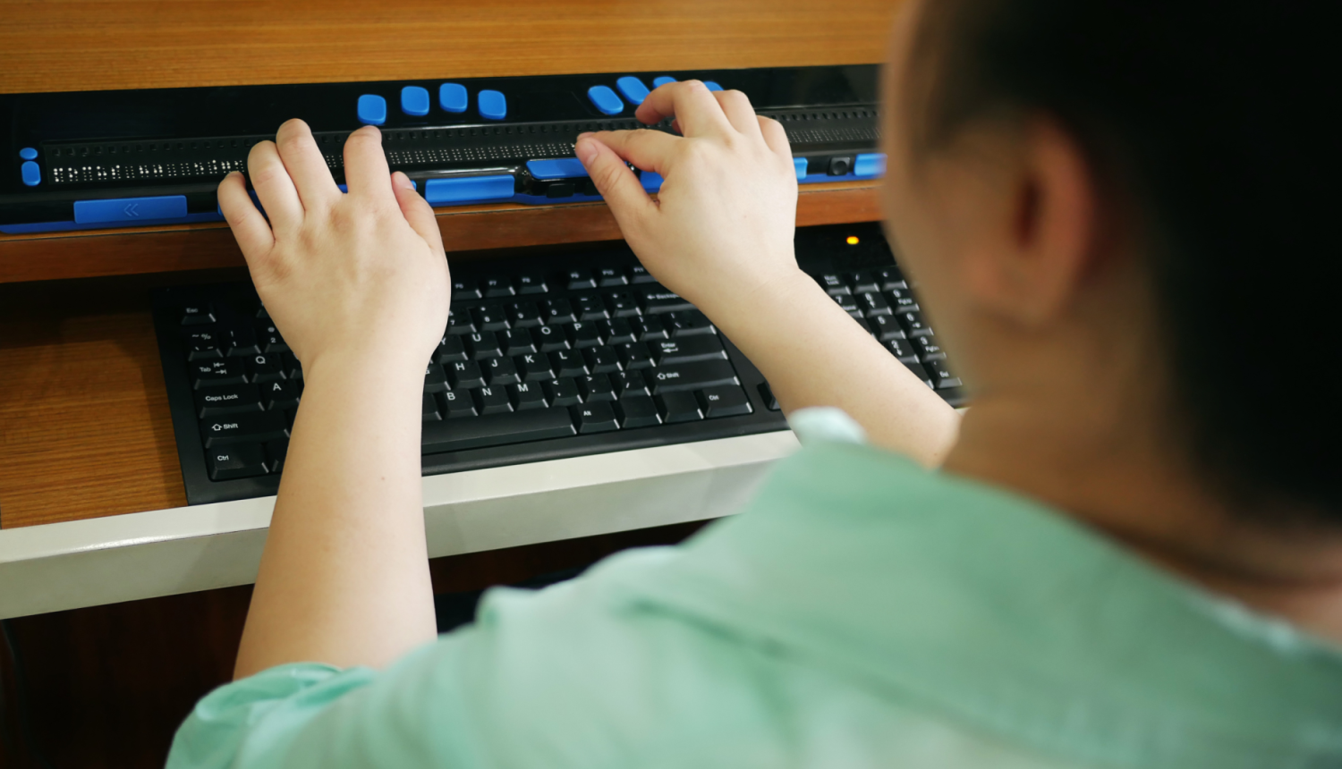 Bērns izmanto braila displeju