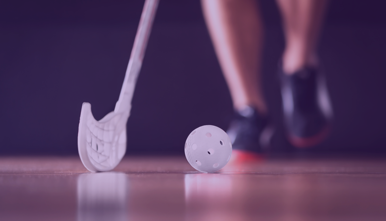 Spotists tur rokās florbola nūju un sit pa bumbiņu