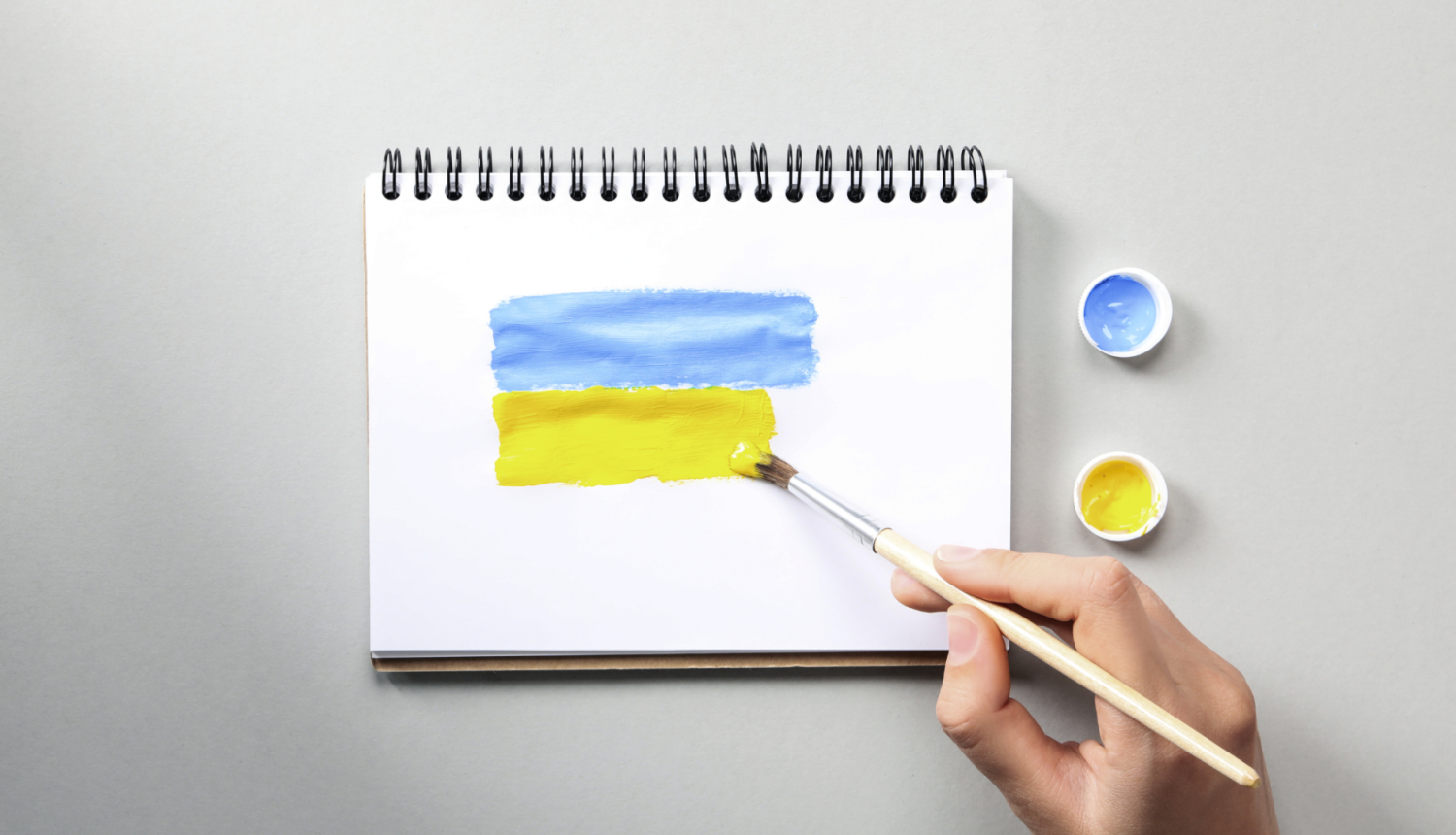 Cilvēks zīmē Ukrainas karogu