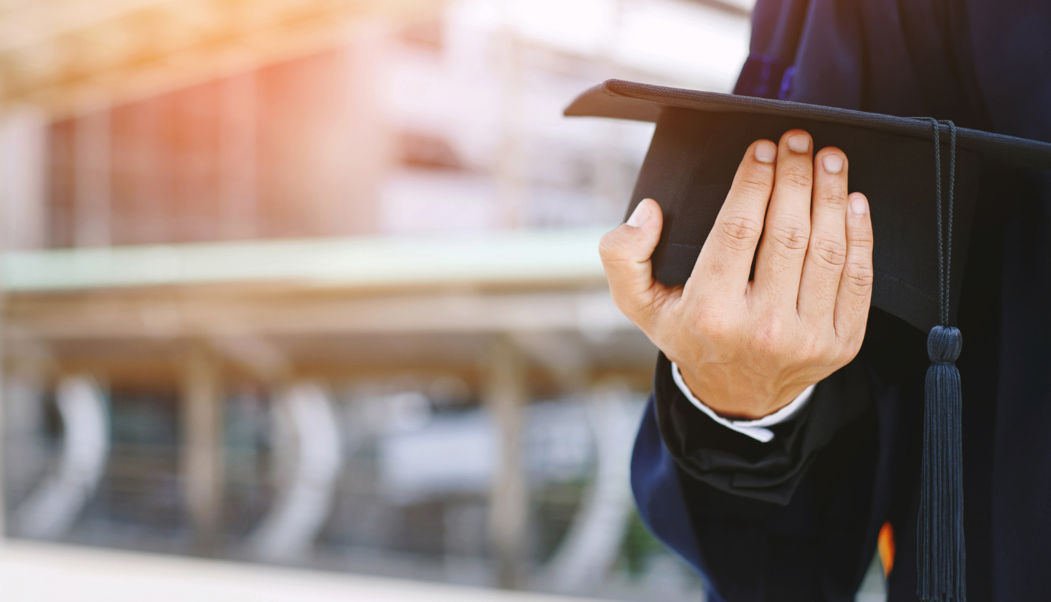 Students rokās tur absolventu cepurīti