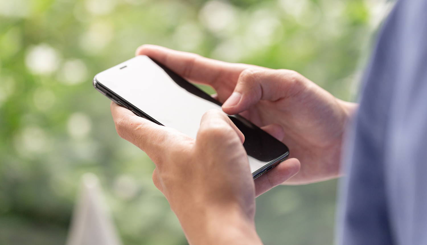 Cilvēks rokās tur telefonu
