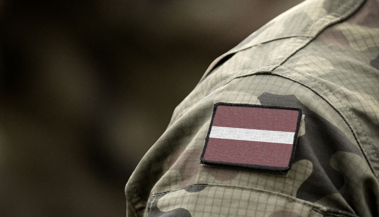 Karavīra uniforma ar piespraustu Latvijas karogu uz pleca