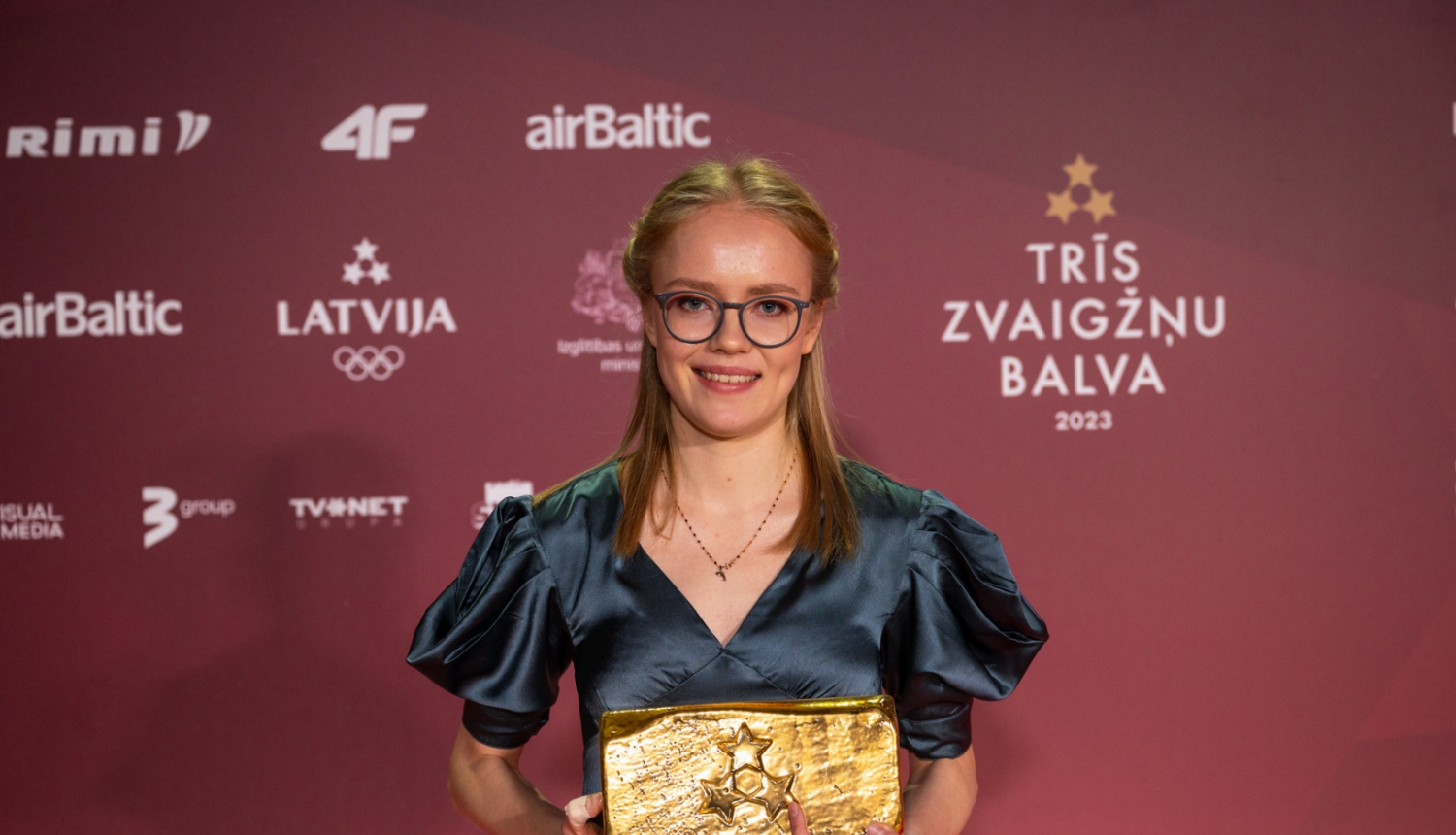 Agate Caune ar Trīs zvaigžņu balvu rokās