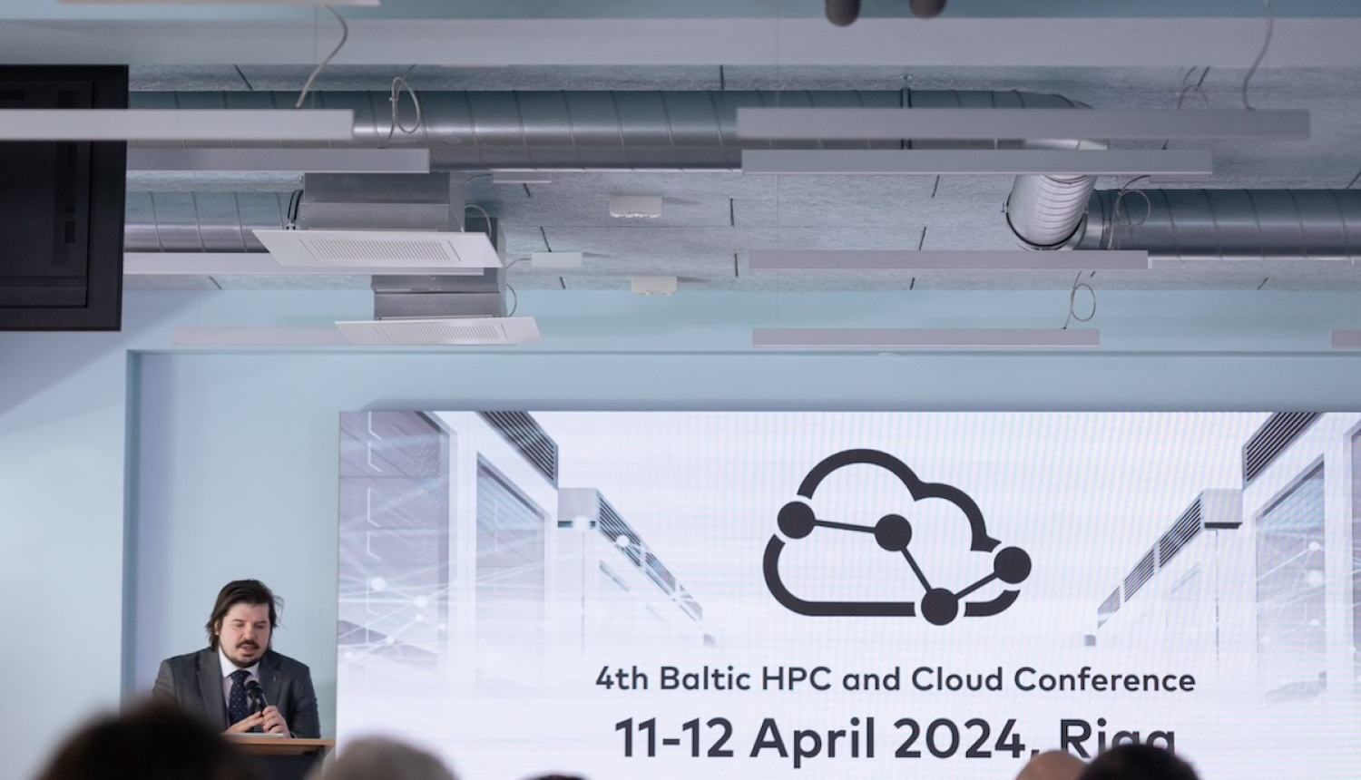 Baltic HPC konference. Auditorijas priekšā uzstājas Jānis Paiders.