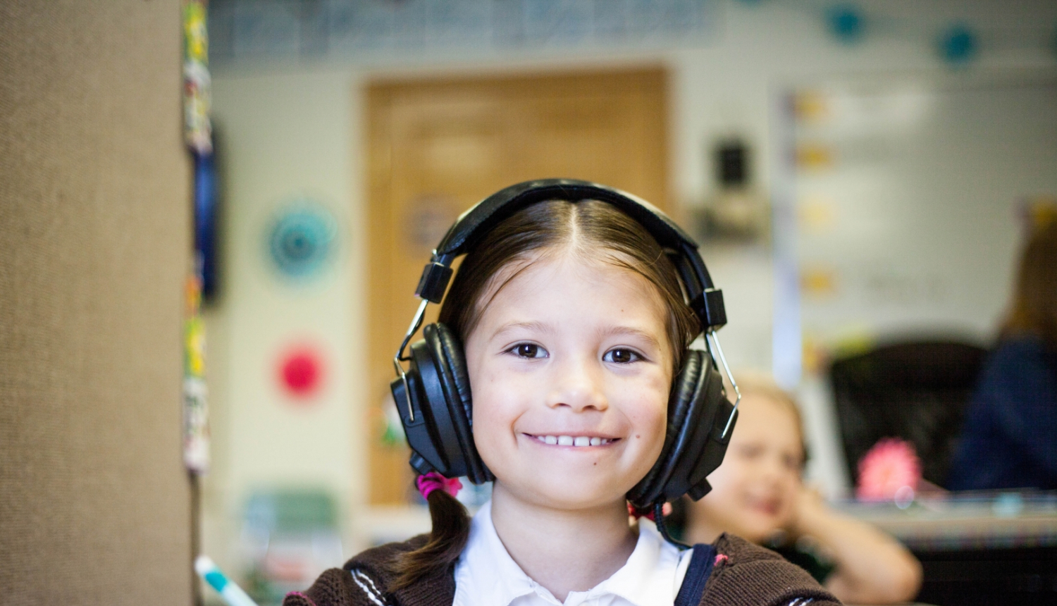 meitene skolas solā ar audio austiņām 