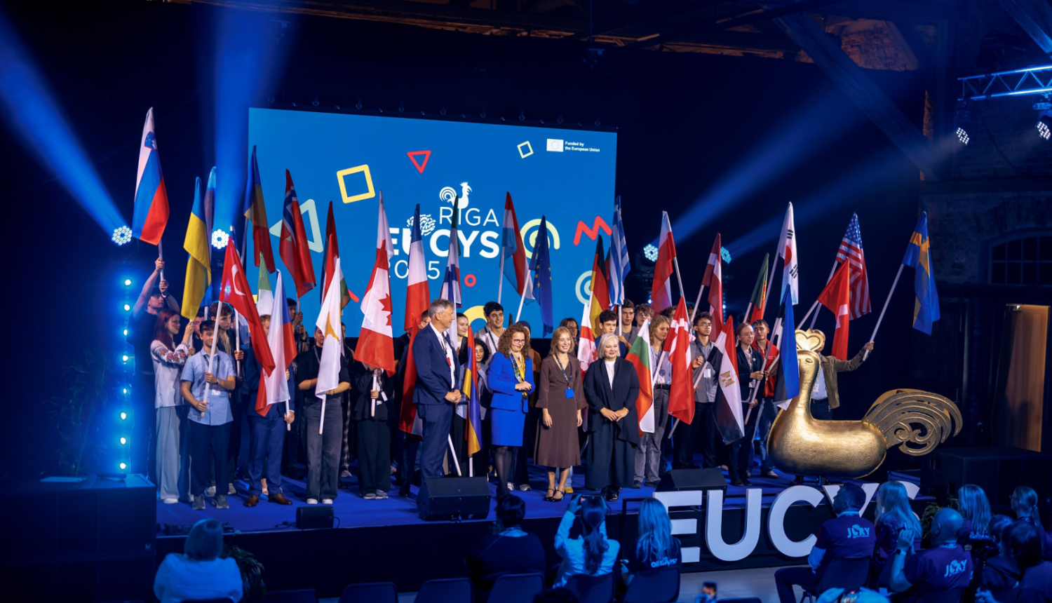 Eiropas Savienības Jauno zinātnieku konkursa EUCYS 2025 atklāšanas pasākums. Dalībnieku kopbilde ar valstu karogiem.