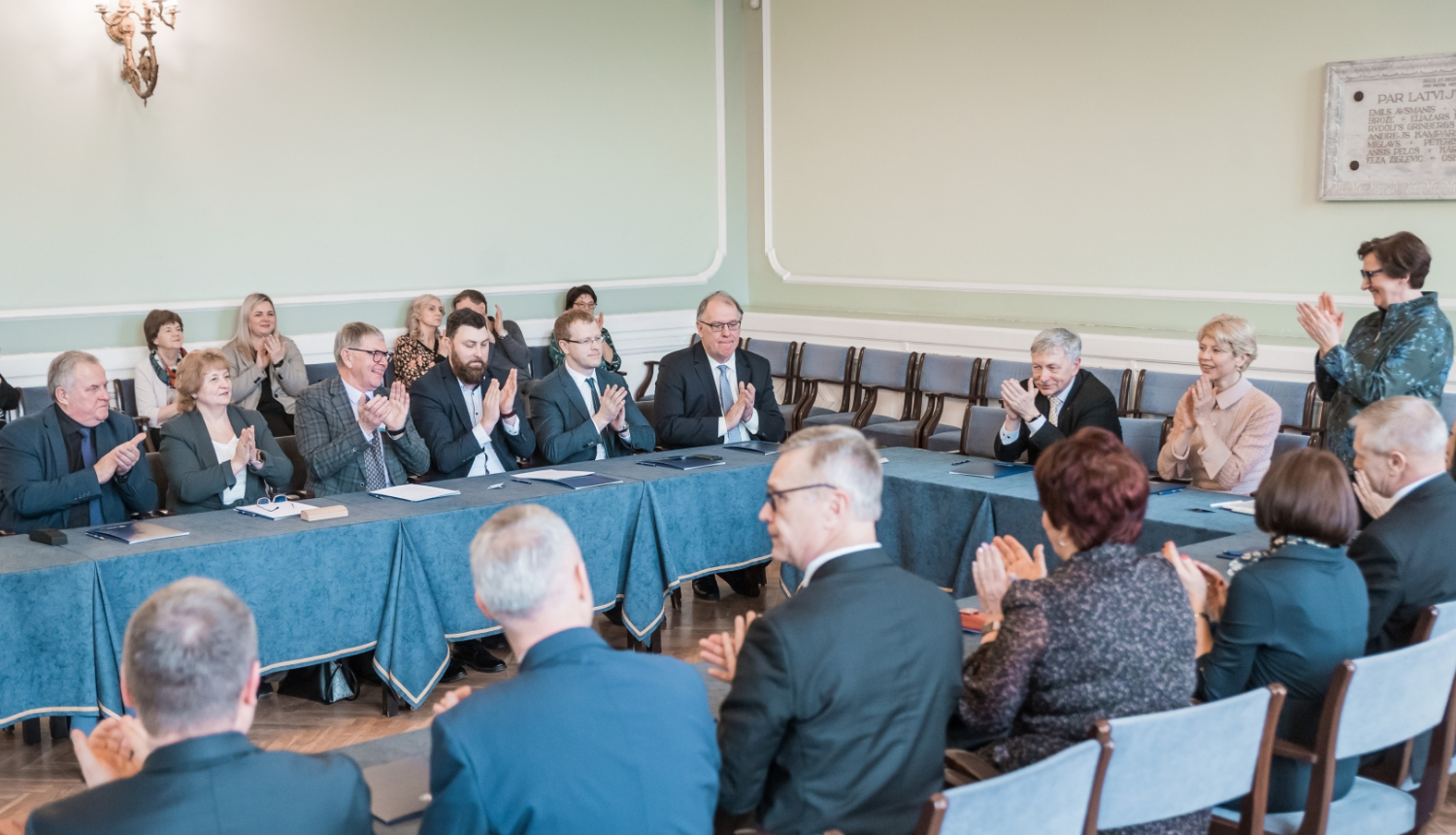 IZM un LU memoranda parakstīšana ar pašvaldībām. Cilvēki sēž ap lielu galdu LU Mazajā aulā