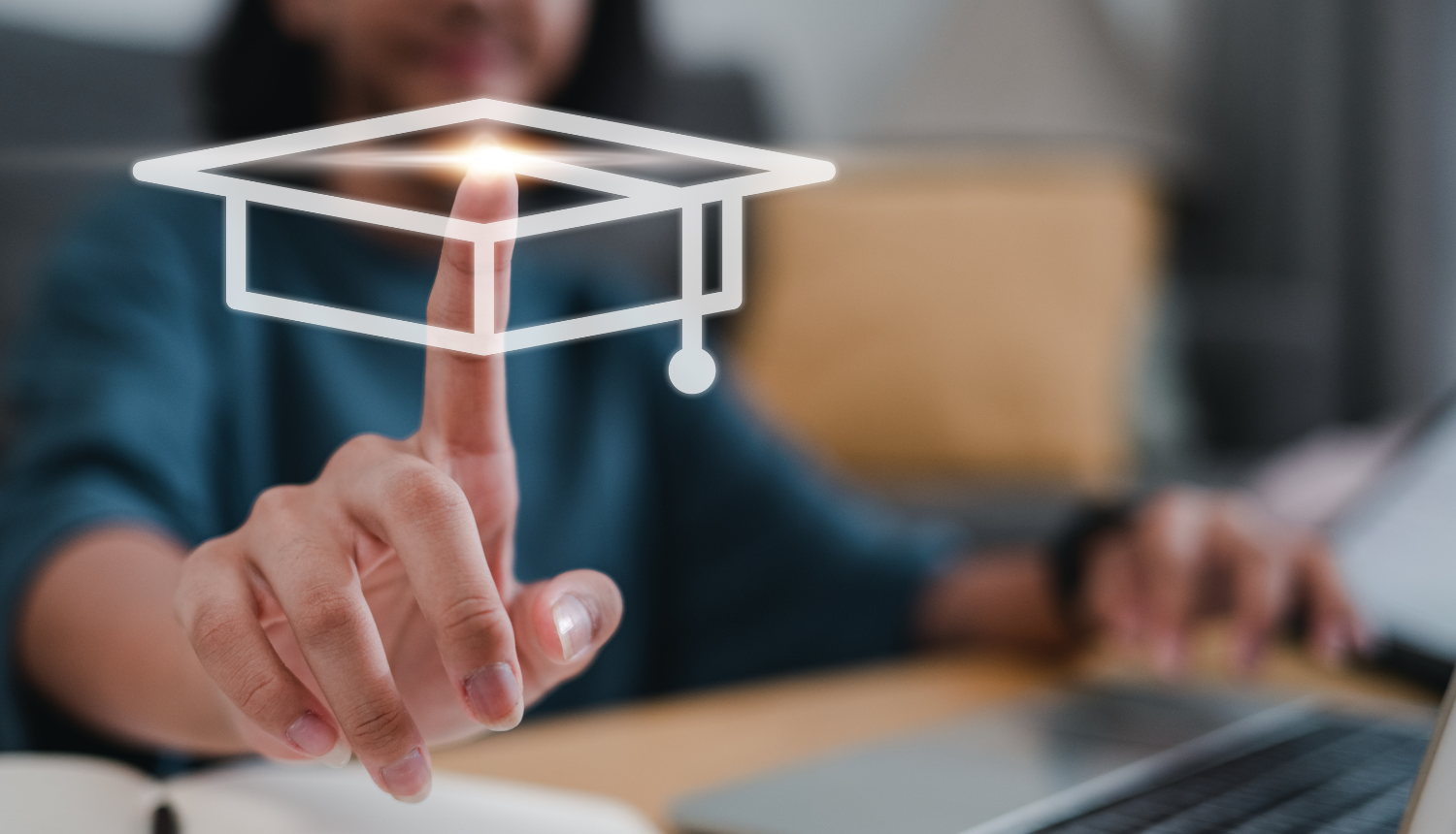 Cilvēka roka priekšplānā, ar rādītājpirkstu uzspiež uz ikoniņas, kas simbolizē izglītību - absolventa cepure