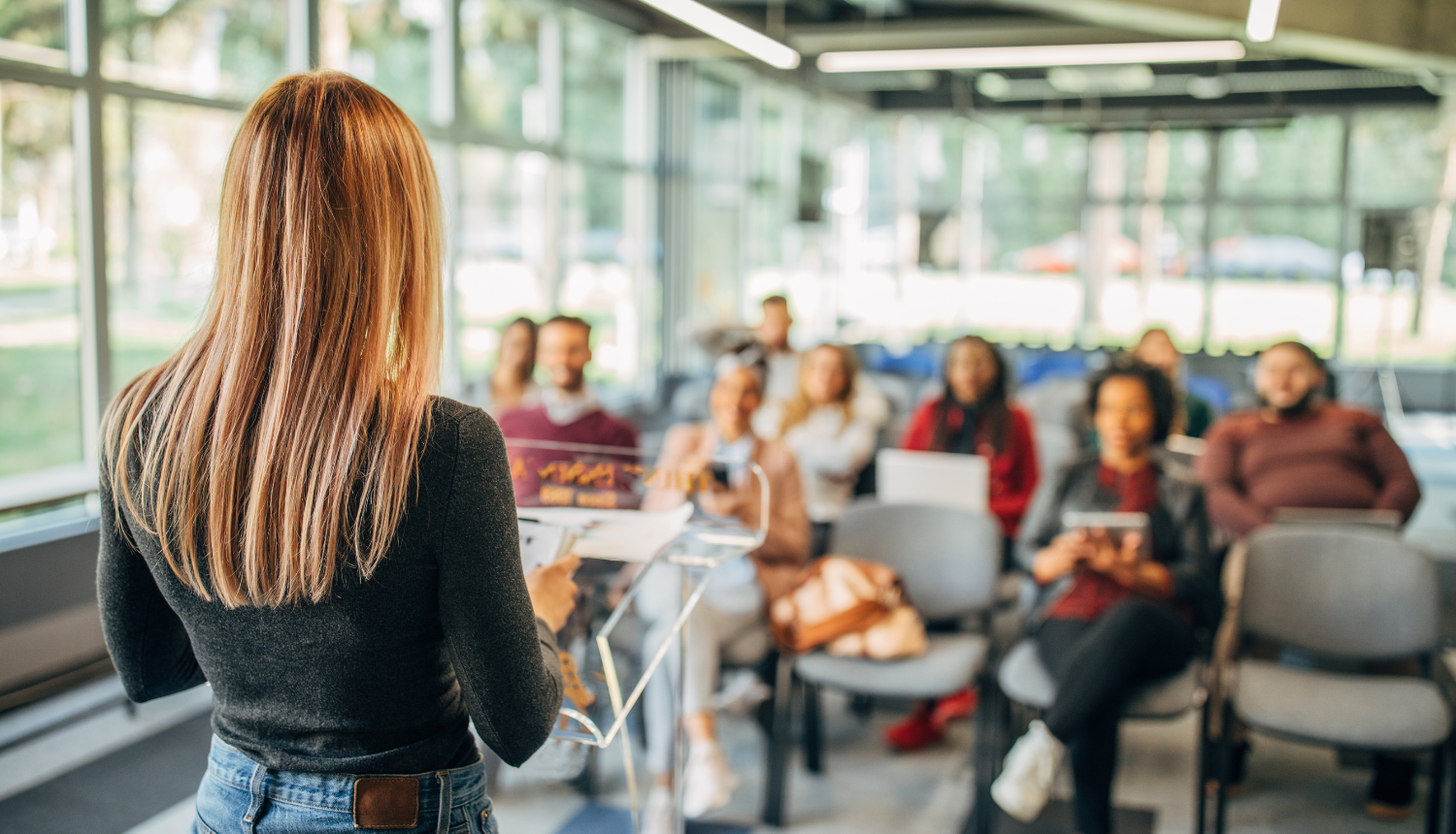 Jauna meitene no murugpuses, stāv auditorijas priekšā