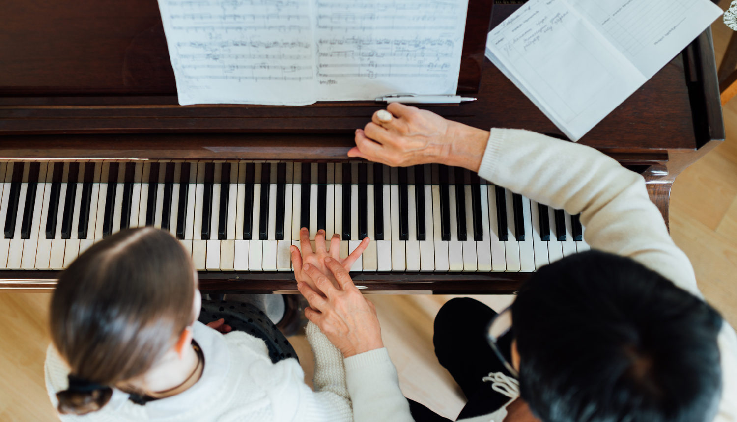 Skolotāja māca meitenei spēlēt klavieres
