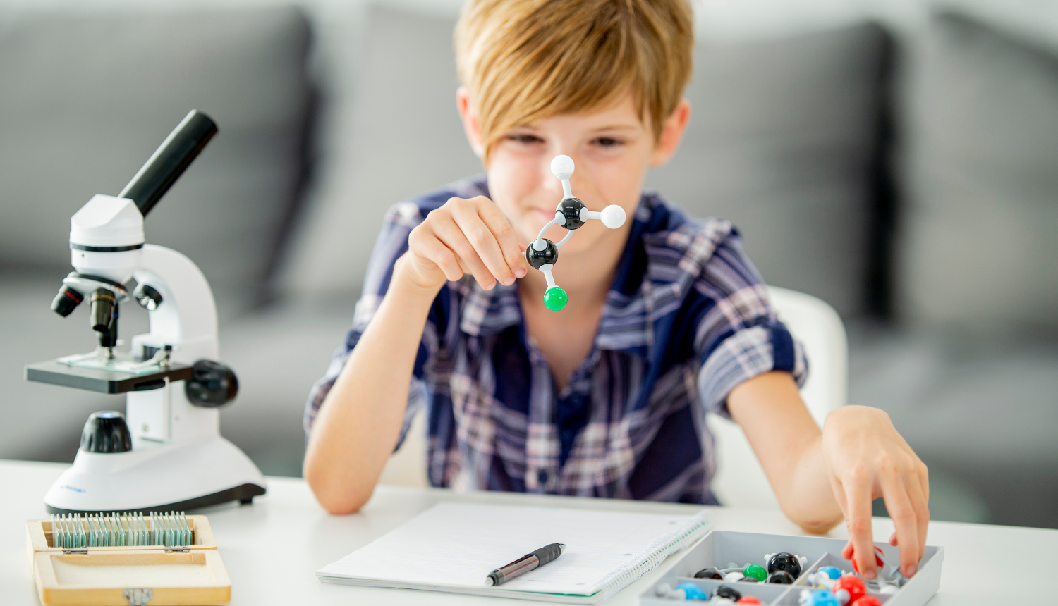 Zēns darbojas ar molekulu formas priekšmetiem