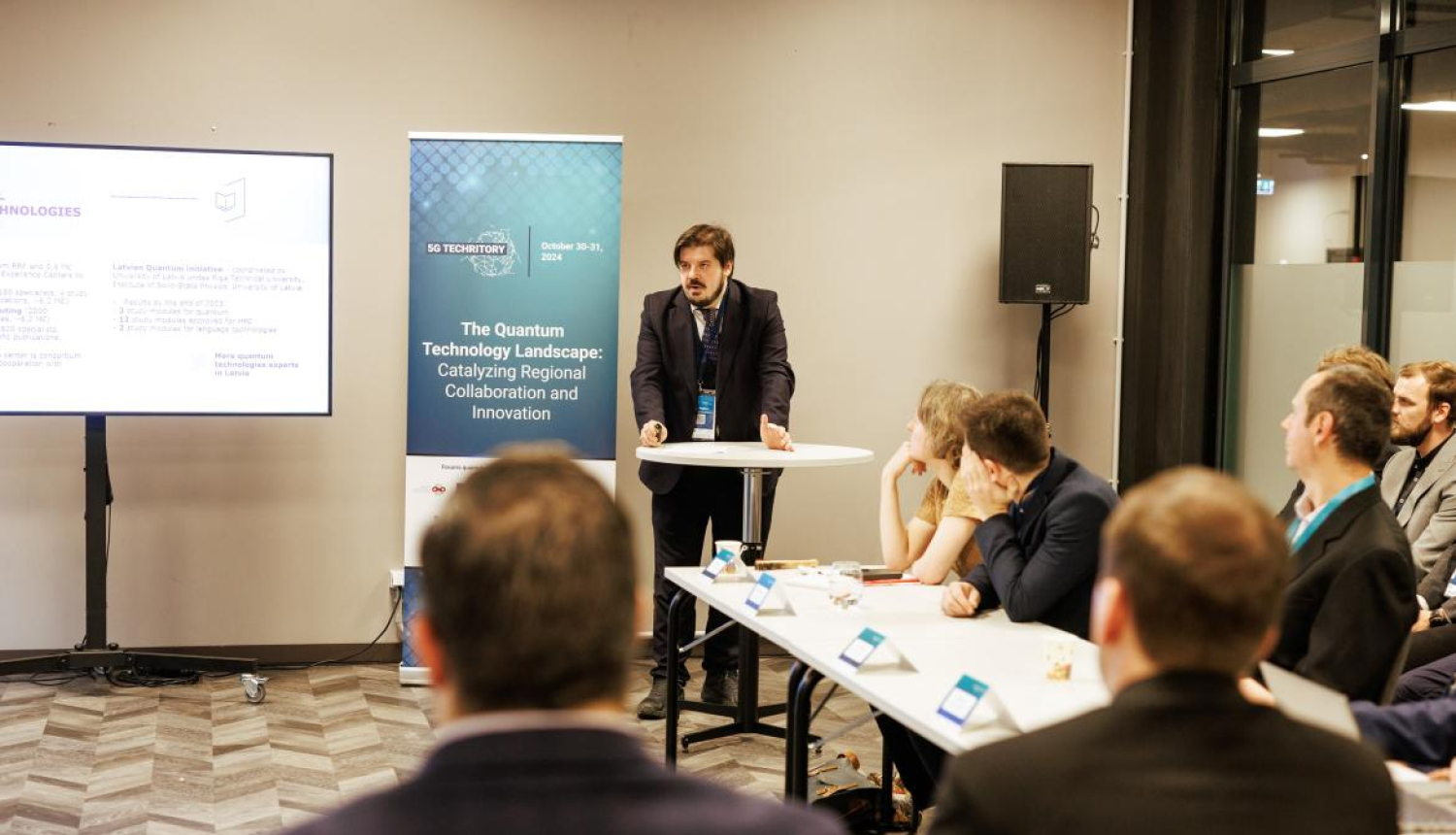 Jānis Paiders saka uzrunu koprades pasākuma “Kvantu tehnoloģiju ainava: reģionālās sadarbības un inovāciju veicināšana” dalībniekiem