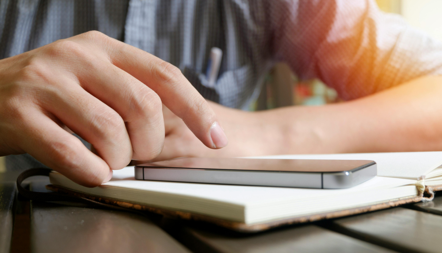 Cilvēks spiež uz telefona ekrāna