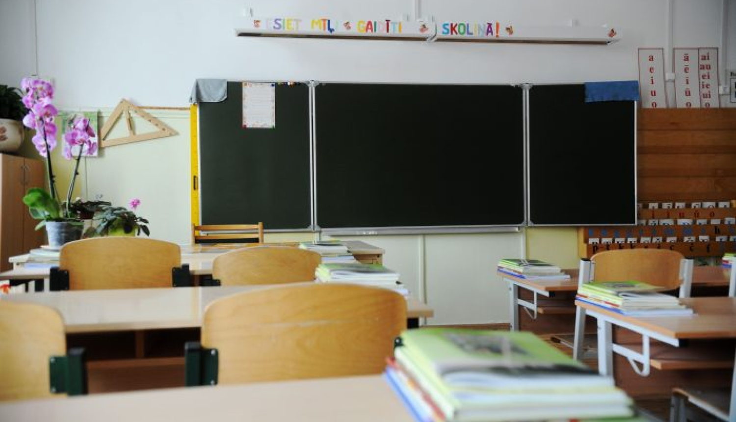 Klase ar skolas soliem, uz sienas redzama tāfele.