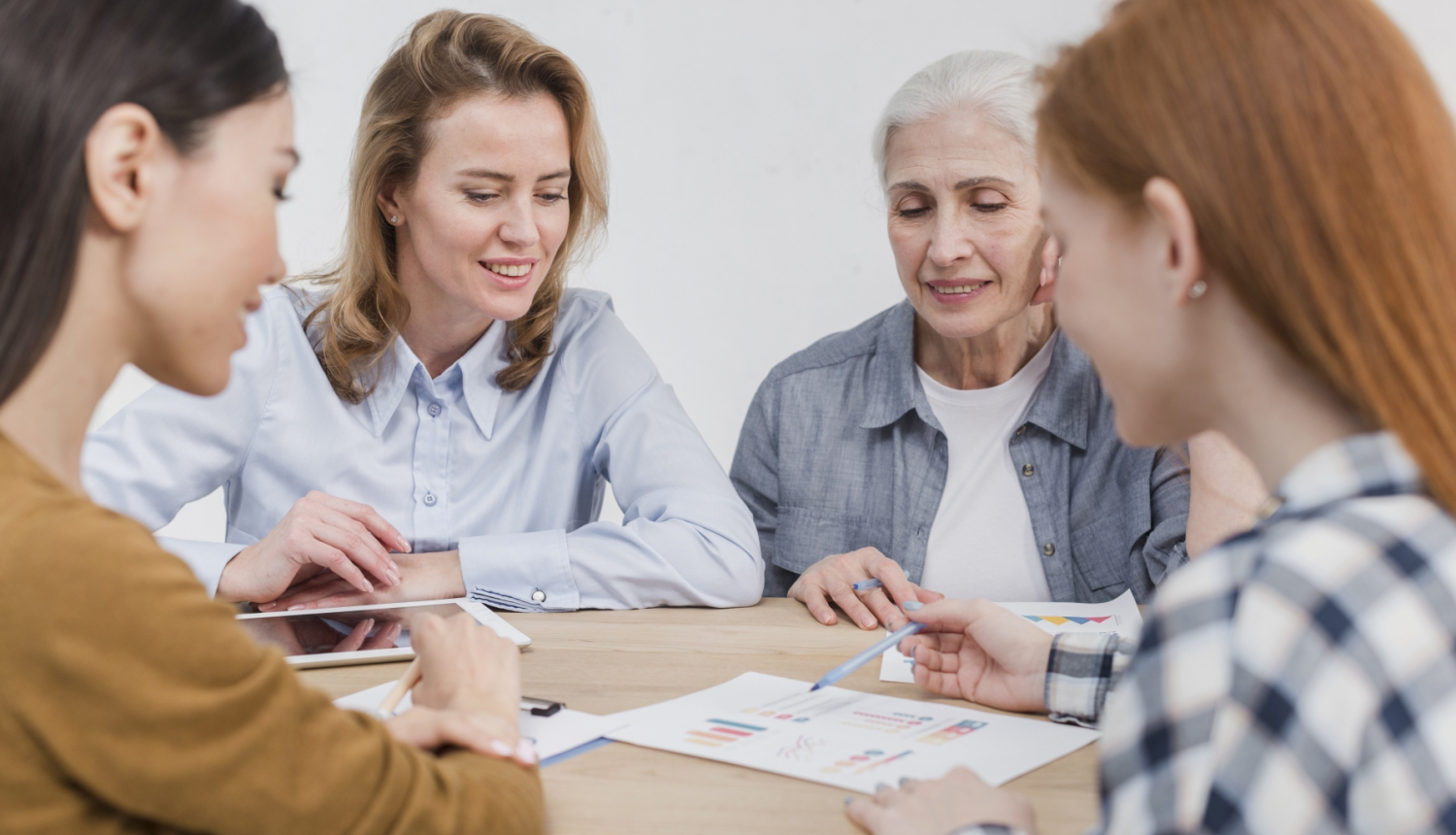 Četras dažāda vecuma sievietes sēž pie galda un pārrunā plānu
