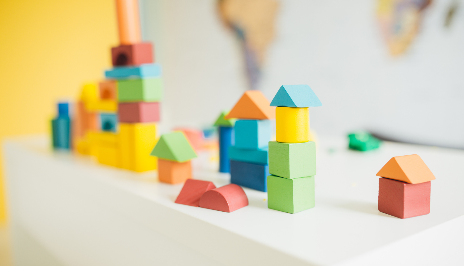 Nelielas krāsainas koka figūriņas saliktas uz galda