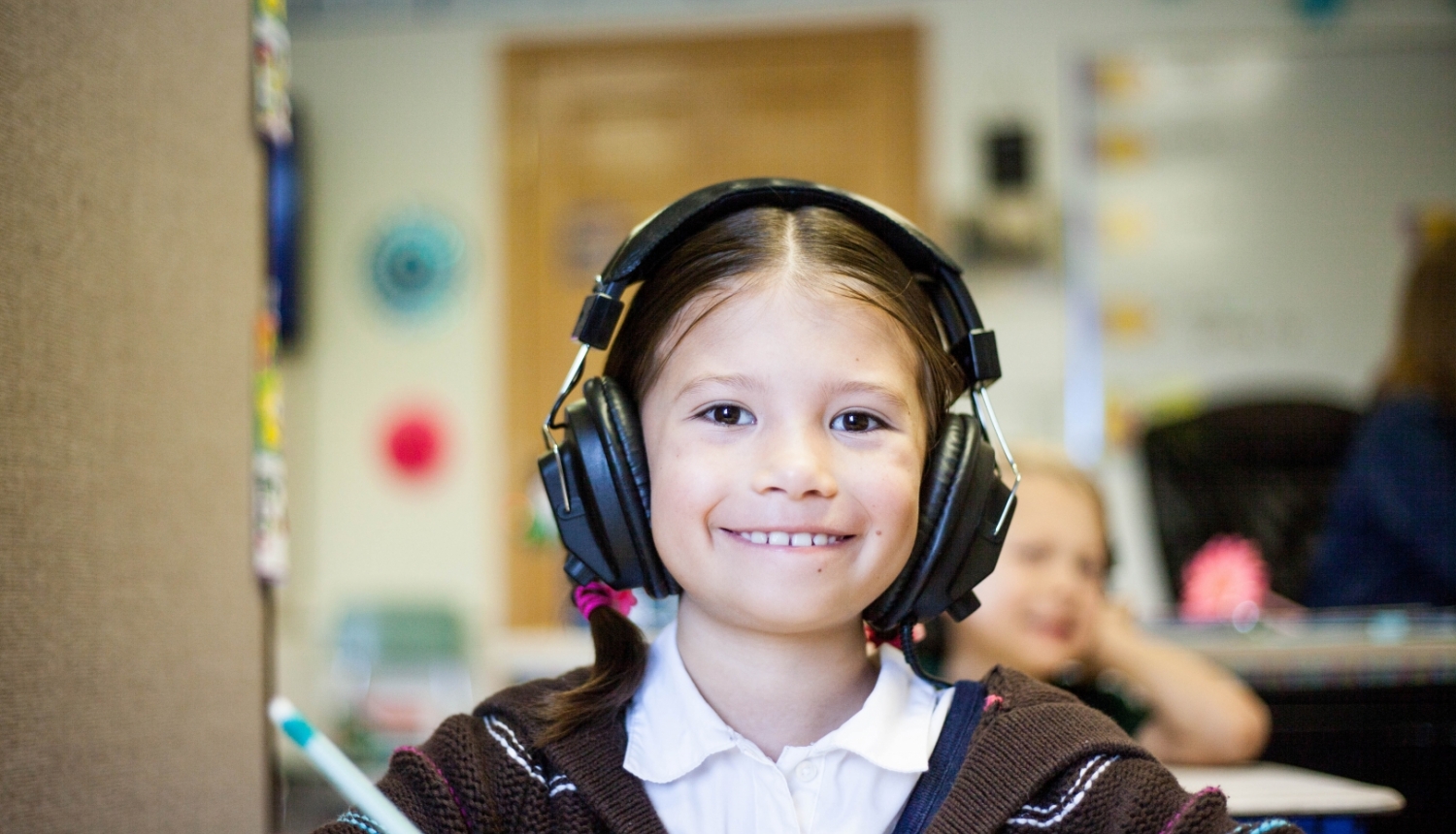 meitene skolas solā ar audio austiņām 